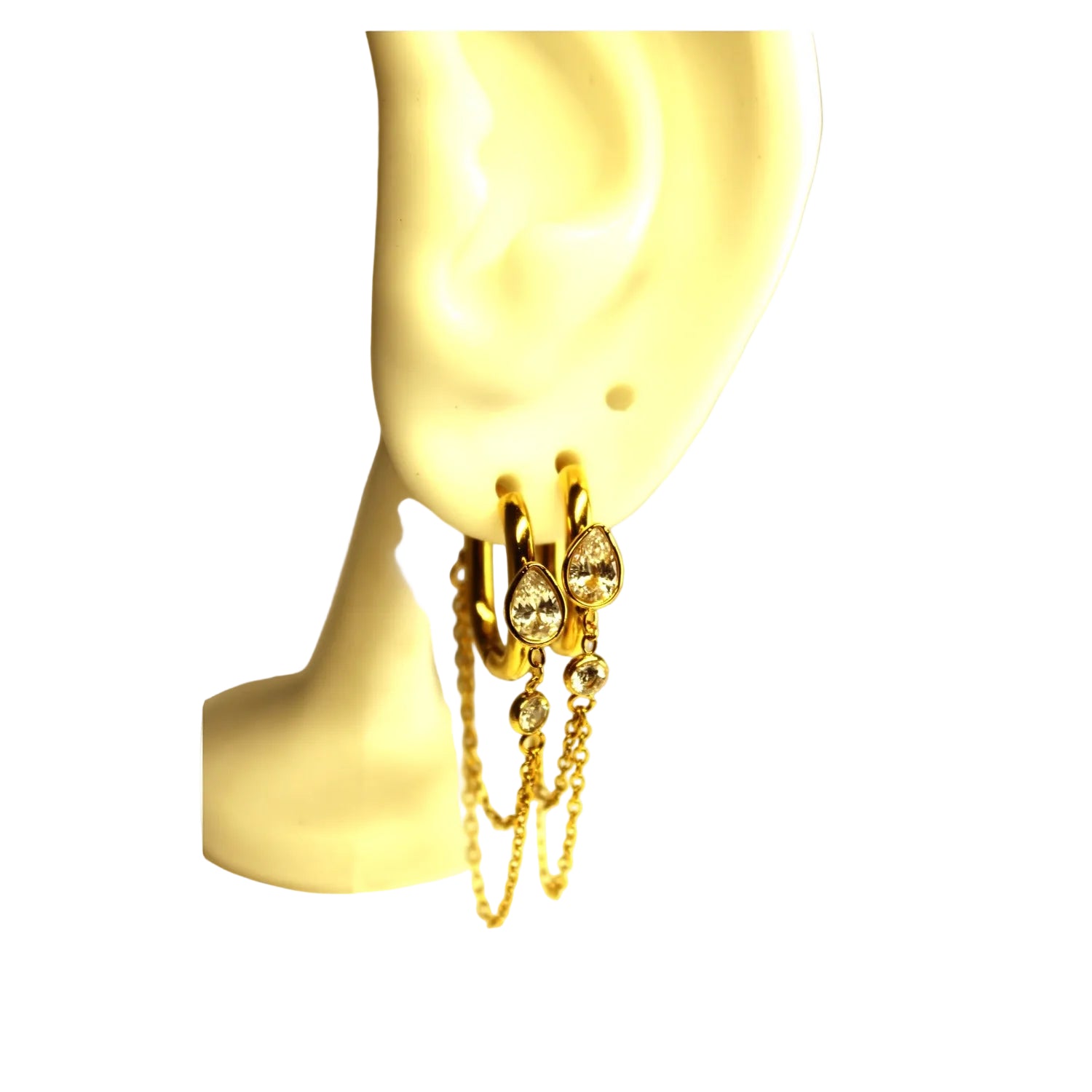 Gold hoop earrings with clear rhinestone accents and dangling chain details, displayed on a cream-colored mannequin ear.